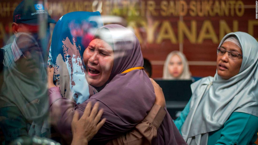 Victims&#39; relatives embrace at a police hospital in Jakarta.