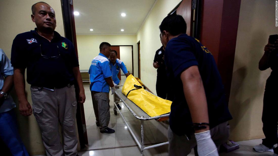 Officials transport a body bag in Jakarta.
