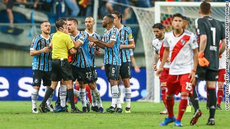 Matheus Bressan confronts referee Andres Cunha after receiving a red card.