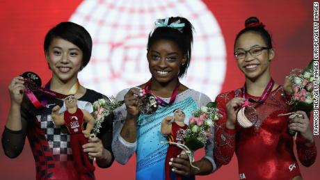 Simone Biles shows off her gold medal at the gymnastics world championships in Doha, Qatar.