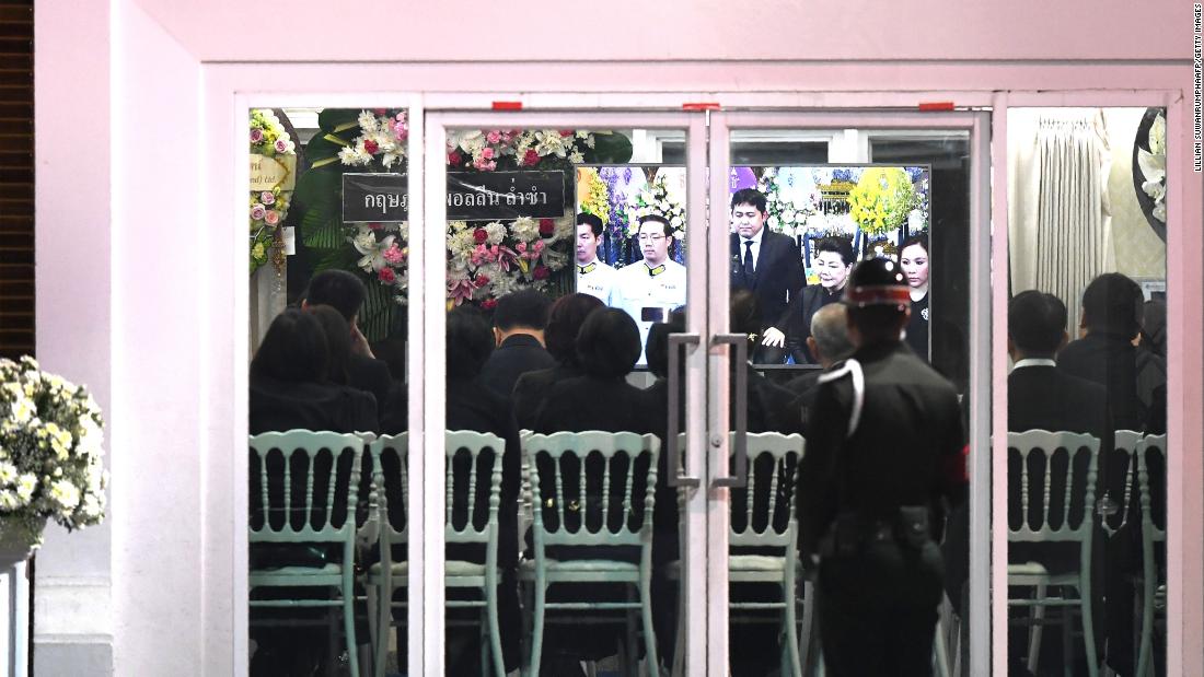 Mourners watch a live feed of Srivaddhanaprabha&#39;s funeral in the Wat Thepsirin temple.