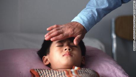 Qi gong master Liang Jian Sheng treats a short-sighted patient by transferring his energy to the young boy at a hospital in Guangzhou. 