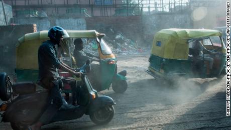 Auto rickshaw drivers pass a building site in Old Delhi. 