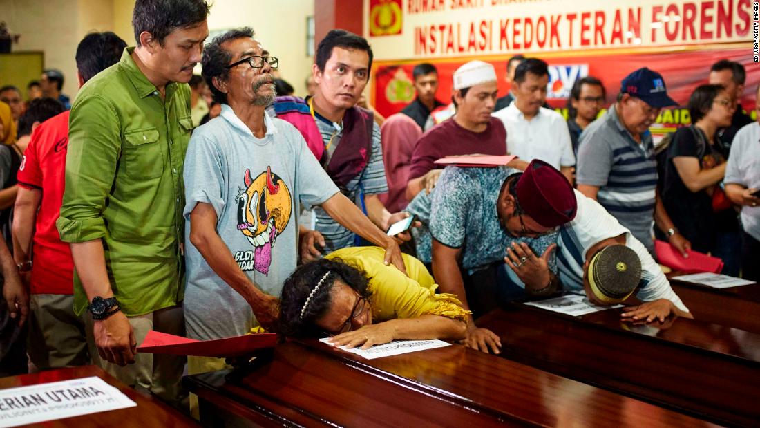 People in Jakarta grieve over the coffin of a relative on November 4.