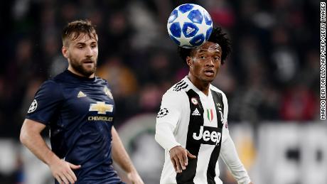 Luke Shaw (L) Juan Cuadrado prepare to compete for the ball.