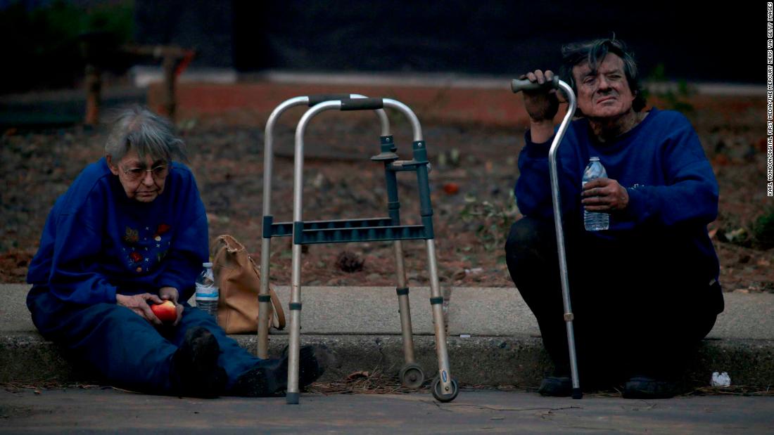 Juanita and Wayne McLish sit on a curb November 8 after losing their house to the Camp Fire in Paradise.