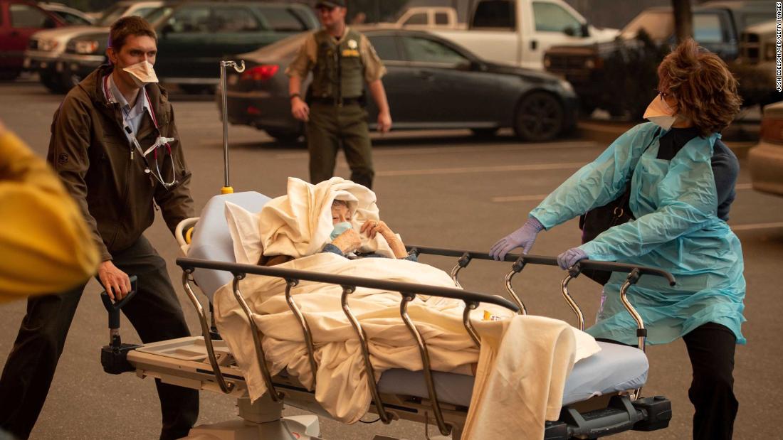 Patients are evacuated from Paradise&#39;s Feather River Hospital as it burns on Thursday, November 8.