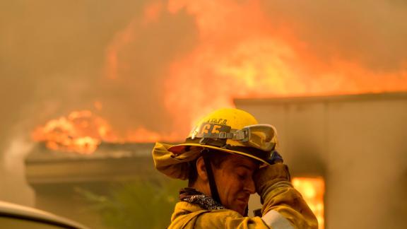 A firefighter keeps watch as the Woolsey Fire burns a home near Malibu Lake on November 9. 