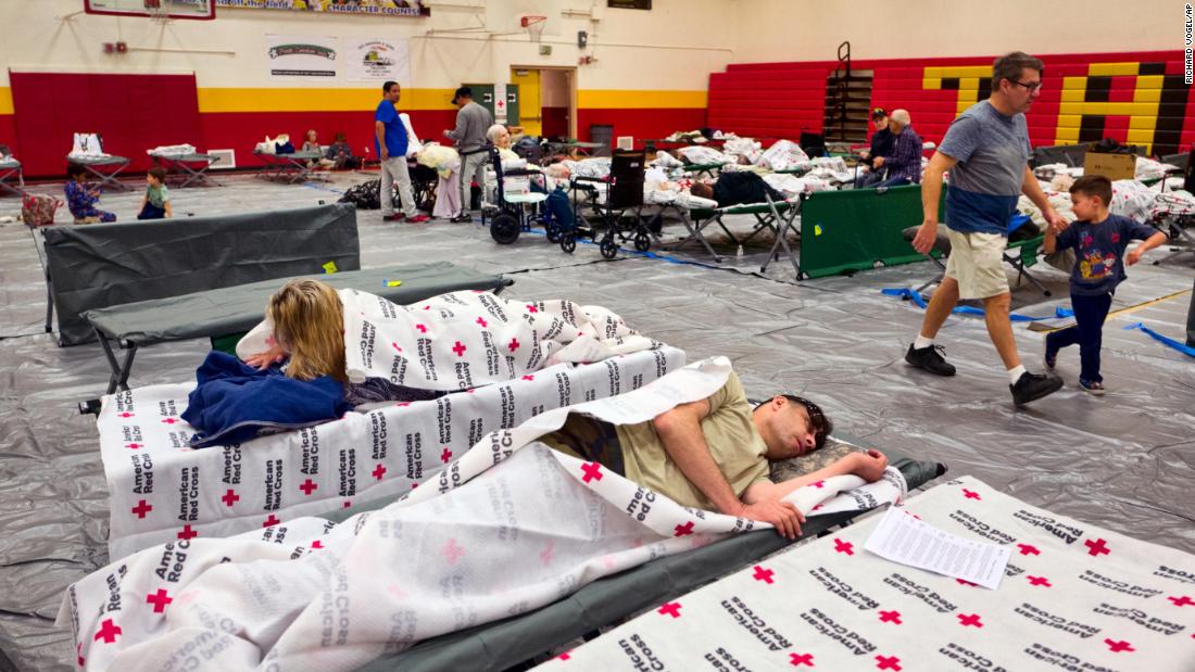 Evacuees rest on cots supplied by the Red Cross at a Los Angeles high-school gym on November 9.