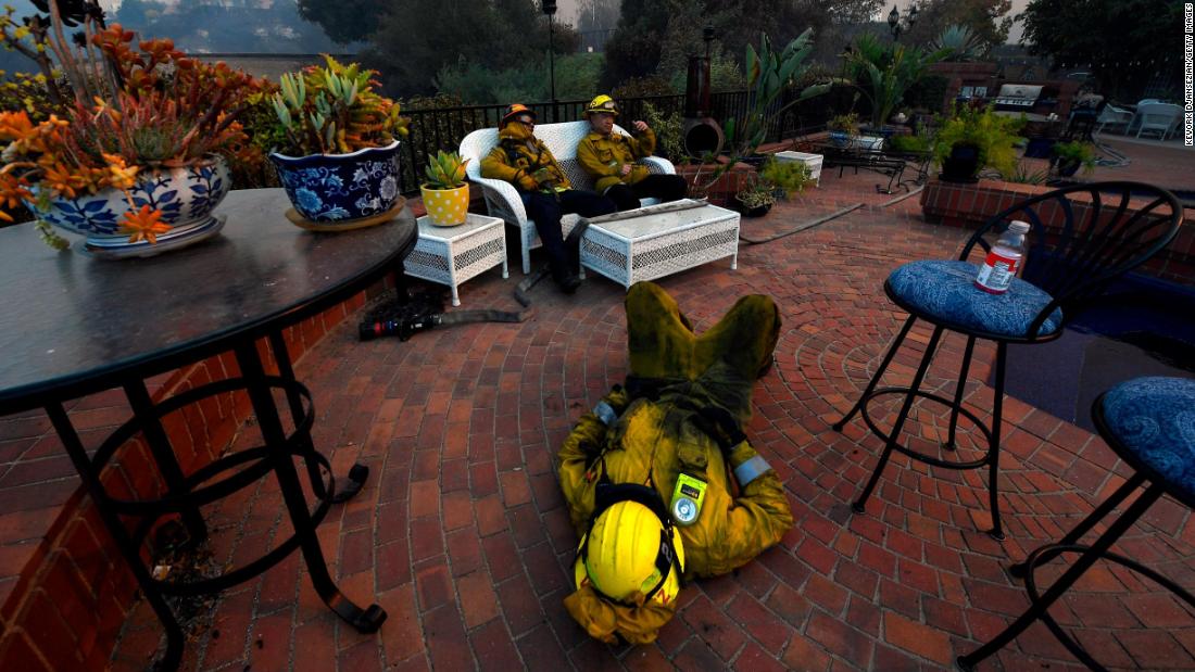 From left, firefighters Cory Darrigo, Omar Velasquez and Sam Quan rest in a Westlake Village backyard after battling the Woolsey Fire all night.