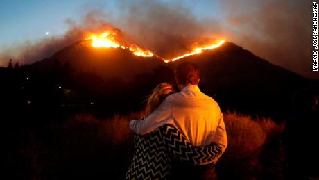 Roger Bloxberg and his wife Anne hug as they watch a wildfire near their home in West Hills, California.