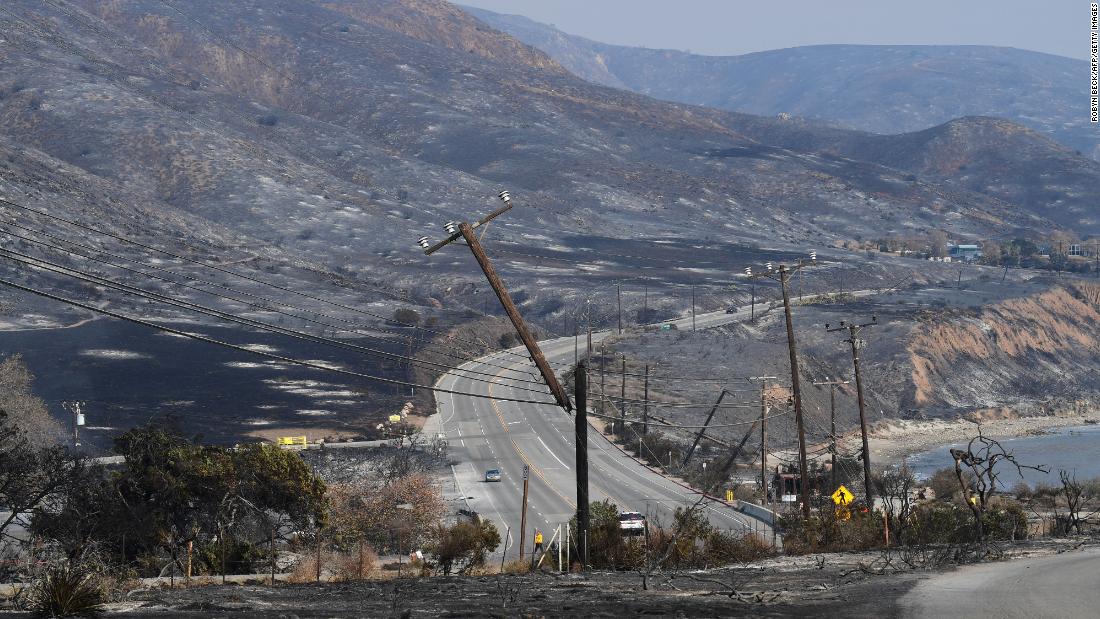 Scorched hillsides and damaged power lines are seen on November 10 along the Pacific Coast Highway in Malibu.