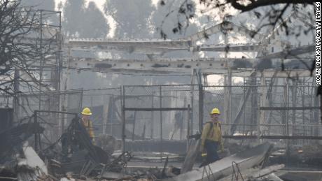 Firefighters look for hotspots in areas destroyed by the Woolsey Fire.