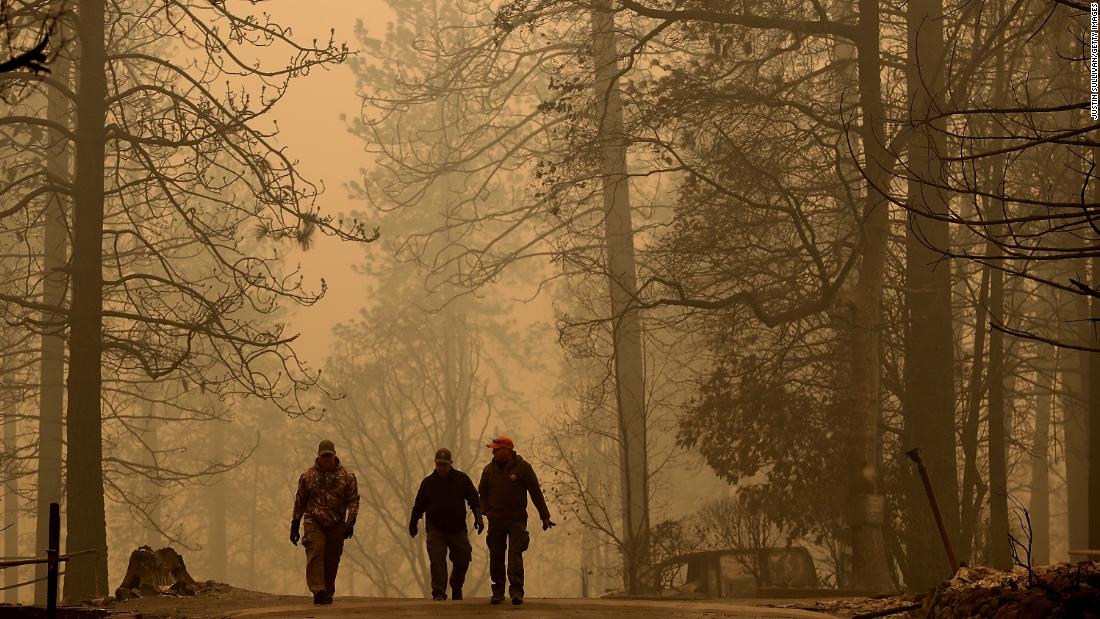 Sheriff&#39;s deputies walk November 10 through a neighborhood destroyed by the Camp Fire.