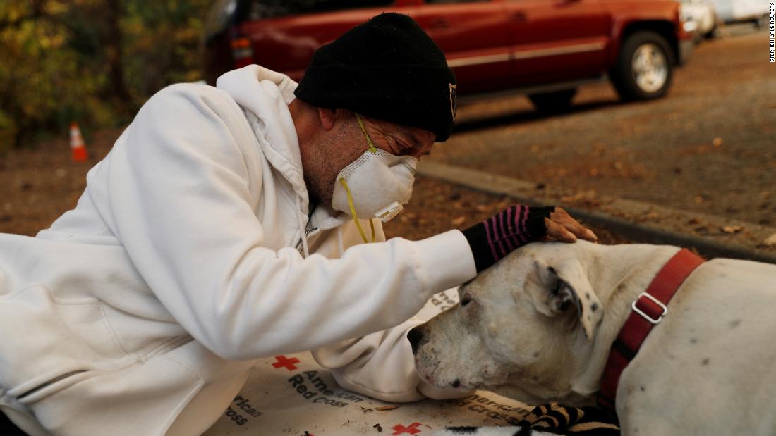 Evacuee Brian Etter and his dog Tone, who escaped the Camp Fire on foot, rest in the parking lot of a Chico church on November 11.