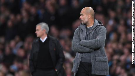 Man City's Pep Guardiola looks on in front of rival Jose Mourinho of Manchester United.