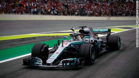 Mercedes' British driver Lewis Hamilton waves from his car after winning the F1 Brazil Grand Prix at the Interlagos racetrack in Sao Paulo, Brazil.