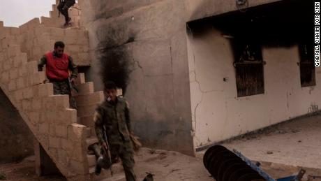 SDF fighters run to take cover during a counterattack by ISIS forces inside SDF lines on October 24 in Sousa, Syria.