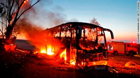 A bus set ablaze after it was hit by a rocket fired from the Gaza Strip, at the Israel-Gaza border near Kfar Aza.