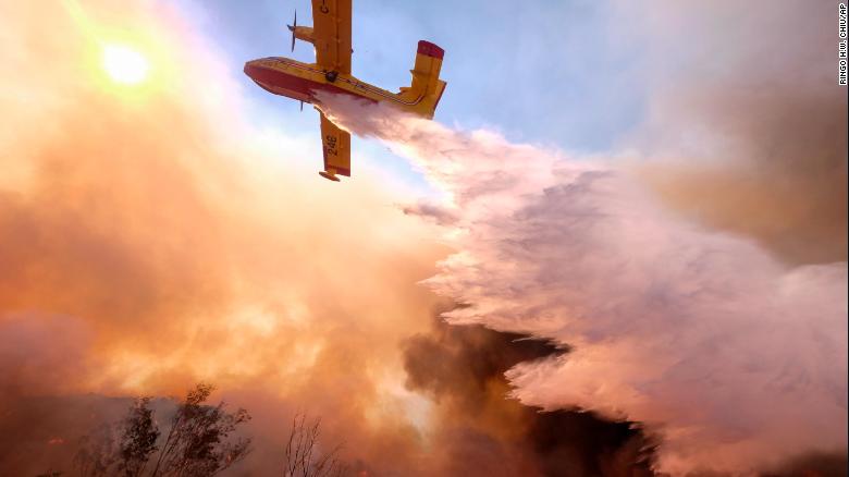 An air tanker drops water on a fire along the Ronald Reagan Freeway in Simi Valley, California, on Monday, November 12. 