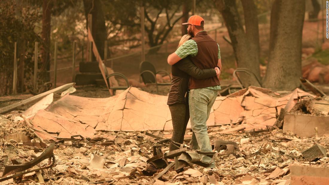 Chris and Nancy Brown embrace while looking over the remains of their home on November 12.