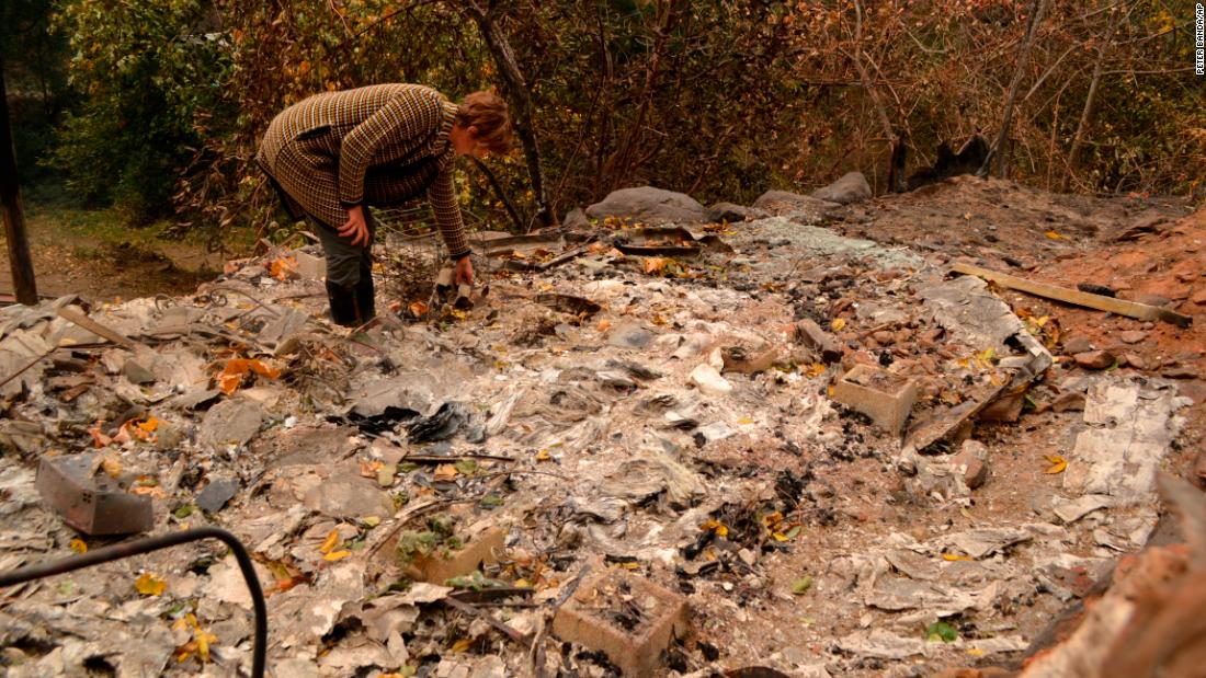 Betsy Ann Cowley walks through Pulga, near where investigators were trying to determine the cause of the Camp Fire.