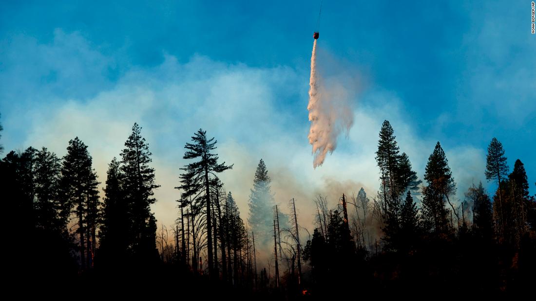 A helicopter drops water while battling the Camp Fire near Pulga on November 11.