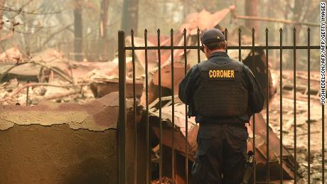 An Alameda County coroner looks for human remains at a burned home in Paradise, California.