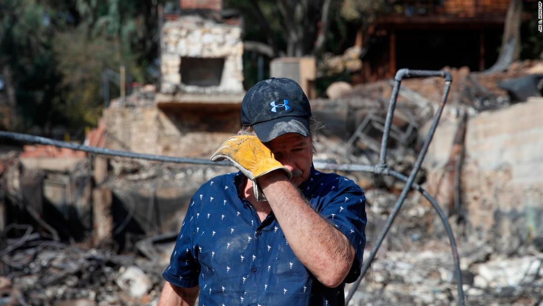 Roger Kelton wipes away tears on November 13 while searching through the remains of his mother-in-law&#39;s home in Agoura Hills. It was destroyed by the Woolsey Fire.