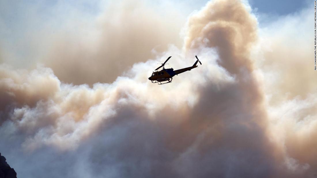 A helicopter flies near the Woolsey Fire burning in the Santa Monica Mountains National Recreation Area.