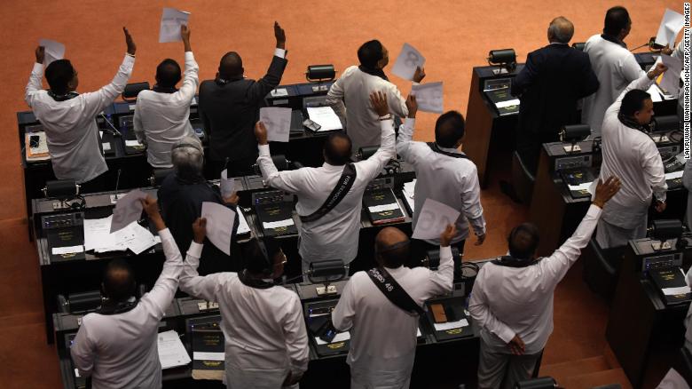 Lawmakers show their support for Sri Lanka&#39;s ousted prime minister Ranil Wickremesinghe during a parliamentary session in Colombo on November 14, 2018. 