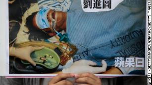 A protester holds a sign showing Ming Pao editor Kevin Lau in hospital after he was attacked in 2014. 