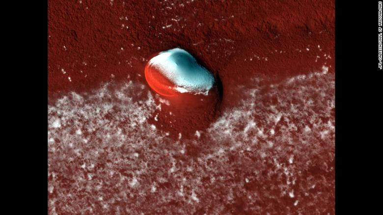 HiRISE captured layered deposits and a bright ice cap at the Martian north pole. 