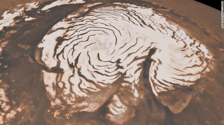 This image, combining data from two instruments aboard NASA&#39;s Mars Global Surveyor, depicts an orbital view of the north polar region of Mars. The ice-rich polar cap is  621 miles across, and the dark bands in are deep troughs. To the right of center, a large canyon, Chasma Boreale, almost bisects the ice cap. Chasma Boreale is about the length of the United States&#39; famous Grand Canyon and up to 1.2 miles deep.