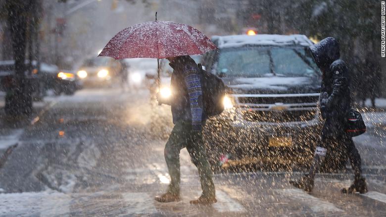 Pedestrians push through a wintry mix of snow and ice Thursday in New York.