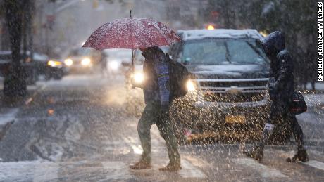 Pedestrians push through a wintry mix of snow and ice Thursday in New York.