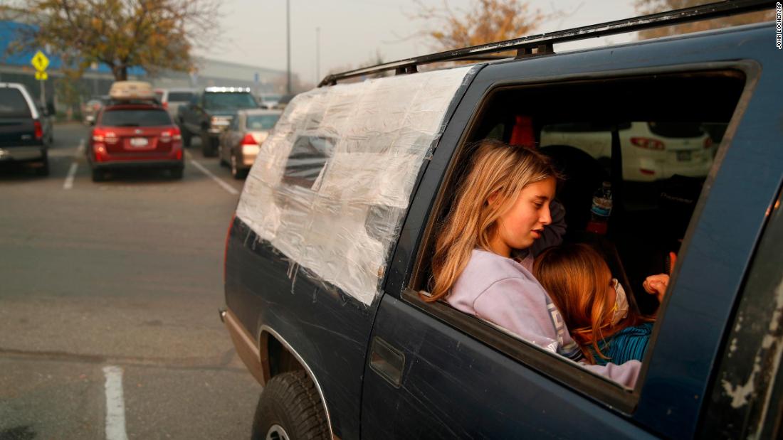 Dakota Keltner, right, rests on Havyn Cargill-Morris on November 16 in a truck at a makeshift encampment outside a Walmart store in Chico, California. The camp became a temporary respite for people displaced by the Camp Fire. 