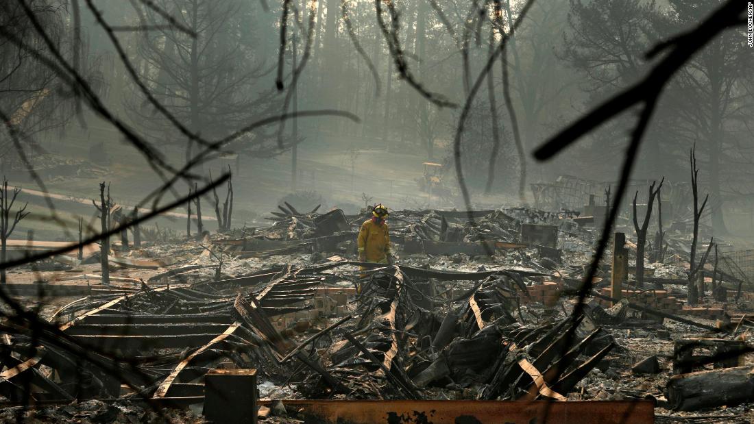 A firefighter searches for human remains on Friday, November 16, in a Paradise trailer park destroyed in the Camp Fire.