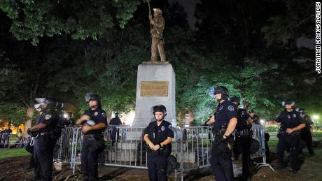 Police wearing riot gear guard a statue of a Confederate soldier nicknamed Silent Sam on the campus of the University of North Carolina. 