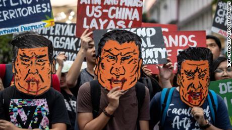 Protesters holds caricatures of Xi Jinping during a protest in Manila.