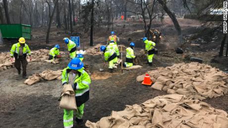 California Conservation Corps members fill out sandbags ahead of significant rain.