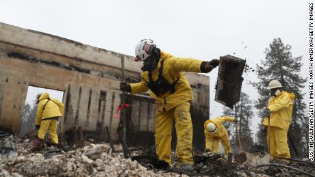 Crews dig through a gutted business in search for human remains in Paradise, California. 