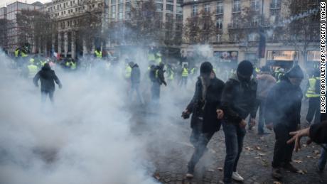 Protesters clash with riot police who fired tear gas canisters in central Paris on Saturday.