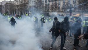 Protestors clash with riot police amid tear gas during a demonstration of Yellow vests (Gilets jaunes) on the Champs Elysees in Paris, on November 24, 2018 during a protest against rising oil prices and living costs. - Demonstrators who have blocked French roads over the past week dressed in high-visibility jackets, are set to cause another day of disruption on November 24 amid calls to bring Paris to a standstill. (Photo by Lucas BARIOULET / AFP) (Photo credit should read LUCAS BARIOULET/AFP/Getty Images)