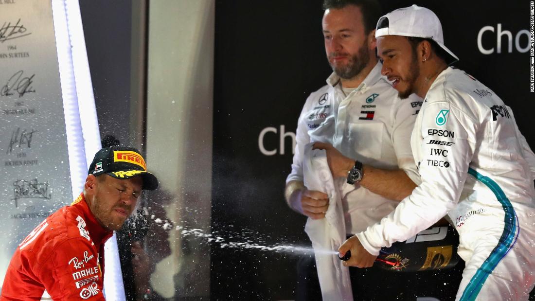 Lewis Hamilton sprays second-placed Sebastian Vettel with champagne after winning the Abu Dhabi season-ending race, 11th of his title winning season.