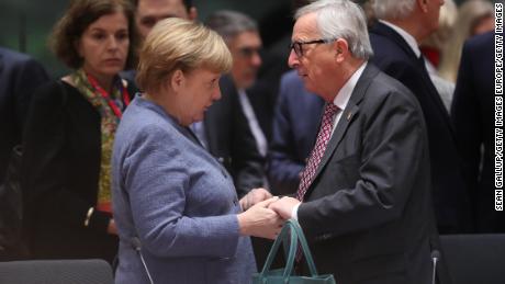 German Chancellor Angela Merkel and European Commission President Jean-Claude Juncker greet each other in Brussels on Sunday.