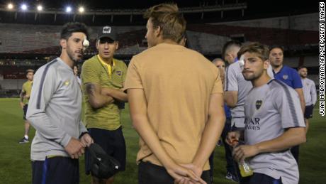 Boca Juniors' Pablo Perez and Gonzalo Lamardo are seen on the field of the Monumental stadium in Buenos Aires with their eyes covered after authorities postponed the all-Argentine Copa Libertadores final.