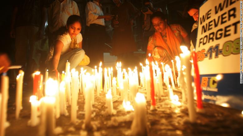 Women place candles outside the Taj Mahal Palace Hotel, in memory of the victims of the 2008 Mumbai terror attacks. 