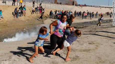 A Honduran mother and children run away from tear gas November 25 in Tijuana, Mexico.