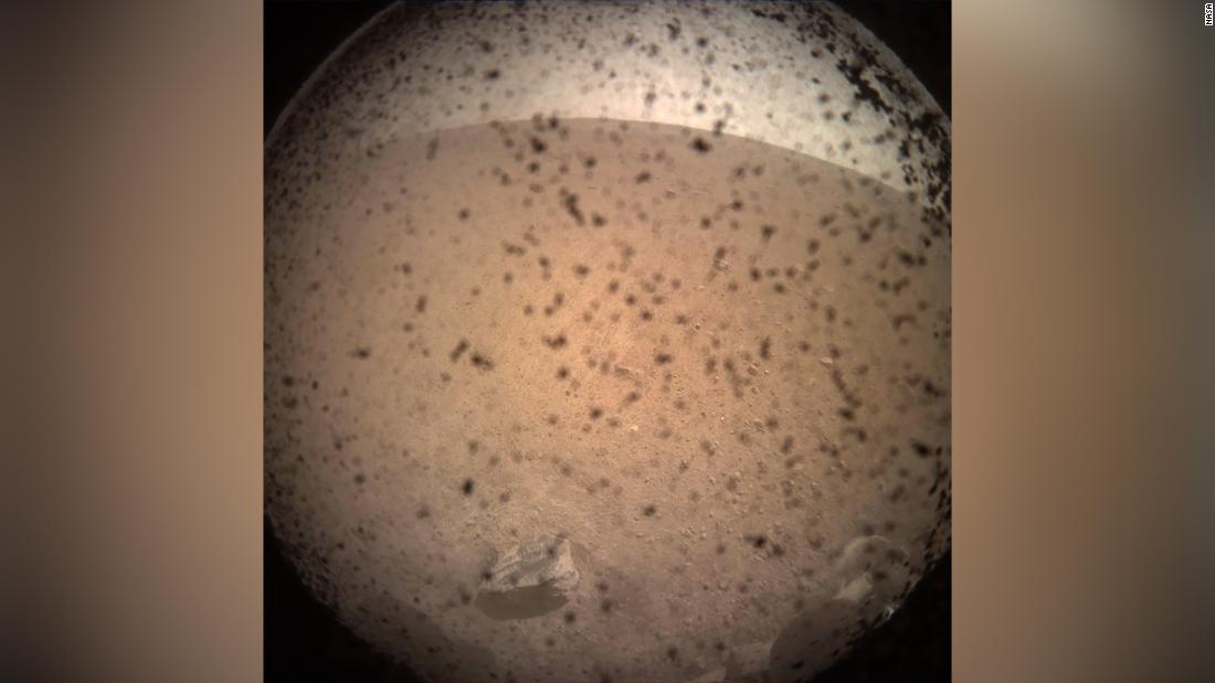 InSight&#39;s first image shortly after landing on the Martian surface on November 26, 2018.This was captured by the lander-mounted, Instrument Context Camera, with the dust shield still attached, to show the area in front of the lander.